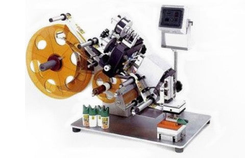 Semi-automatic tamp labeler for short production runs of flats or ovals, or for difficult to handle parts, model CVC 120, by Acasi Machinery Inc.
